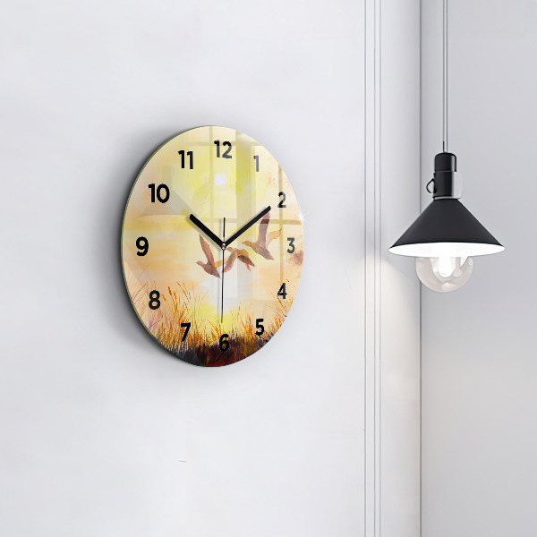 Round glass clock Cranes at sunset