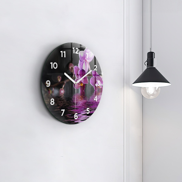 Round glass clock Orchid flower on the water