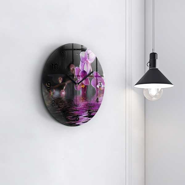 Round glass clock Orchid flower on the water