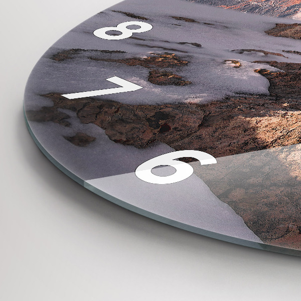 Round glass clock A mountain covered in snow