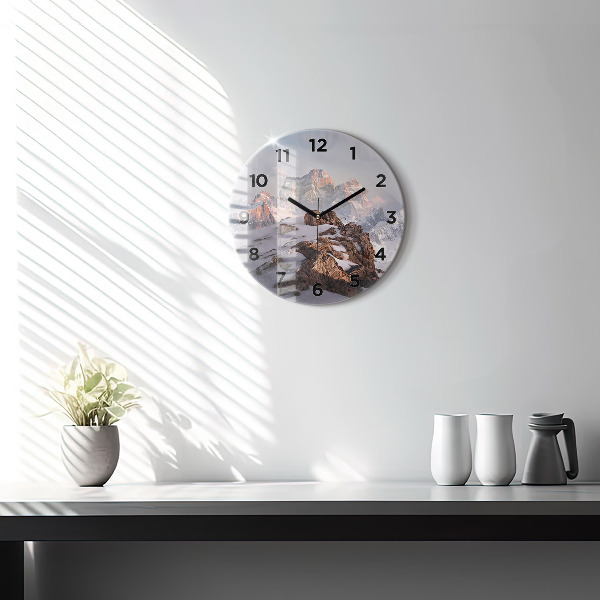 Round glass clock A mountain covered in snow