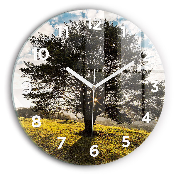 Round glass clock A tree on a hill