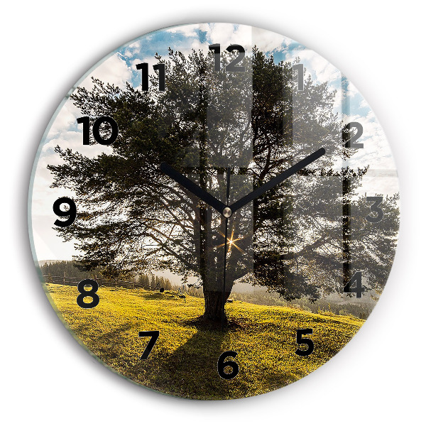 Round glass clock A tree on a hill