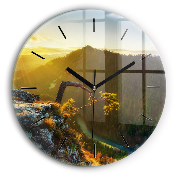 Round glass clock Sunset over the mountains