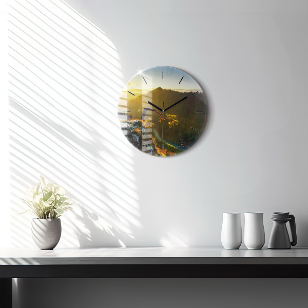 Round glass clock Sunset over the mountains