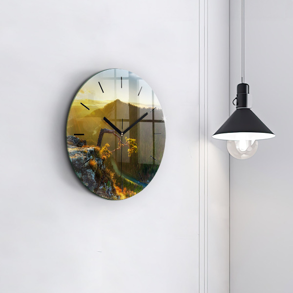 Round glass clock Sunset over the mountains