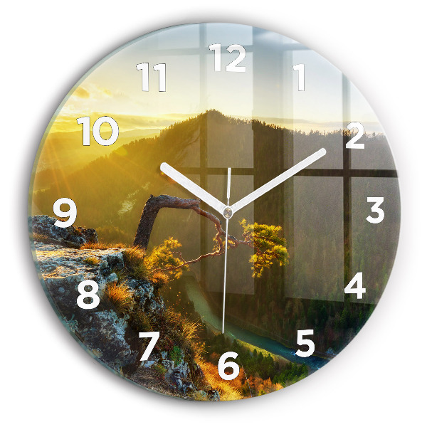 Round glass clock Sunset over the mountains