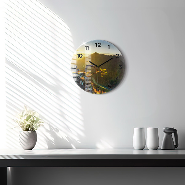 Round glass clock Sunset over the mountains