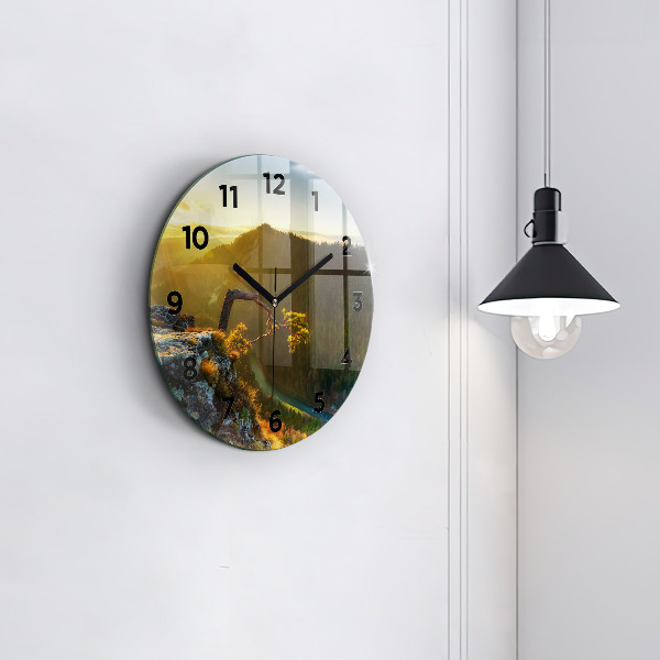 Round glass clock Sunset over the mountains